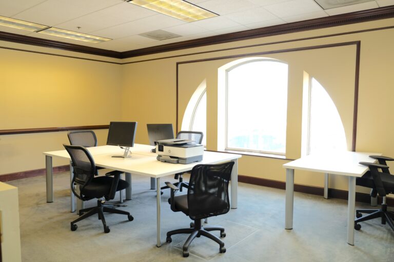 Large office with arched windows, desks, and office chairs.